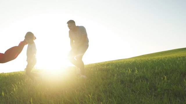 Father and son play outdoor. Happy father and son play bullfight in a summer meadow