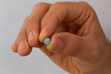 hands holding pills in different positions, with a flat background, concept of cure for diseases
