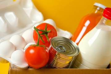 Set of food in a box on a yellow background. Food donations during quarantine and coronavirus.
