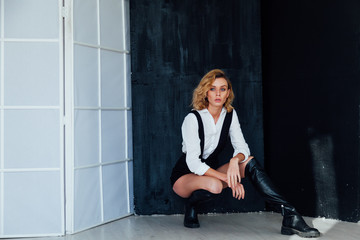 Portrait of a beautiful young fashionable blonde woman in a shirt and black shorts