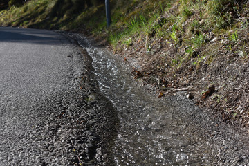 Trinkwasser Ableitung mit Wasserverschwendung am Straßenrand, Welle von Wasser
