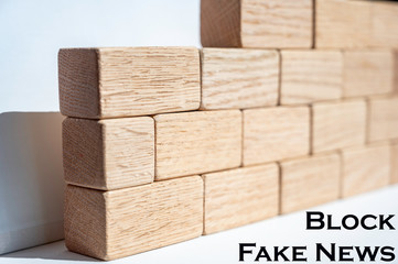 Wooden building blocks forming a wall as a concept to "Block Fake News"  