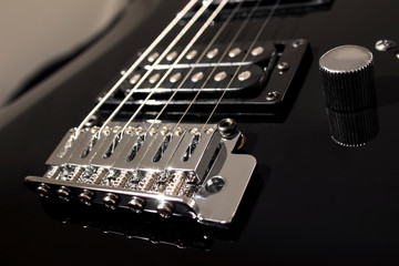 Electric guitar close-up black. Separate elements, strings, pickups. Background in blur.