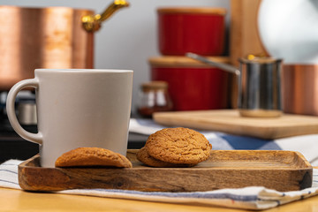 Cup of hot coffee on wooden board on kitchen table close up