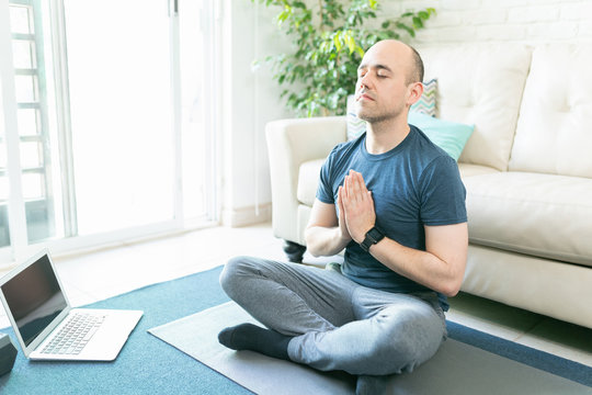 Man Doing Yoga From A Laptop At Home