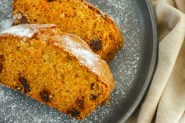 Two pieces of carrot cake with raisins on plate