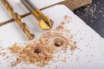 Drilling in a furniture board. Making a hole and countersinking for a metal screw.