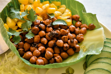Closeup shot of brown chickpea and corn in plate during the breakfast