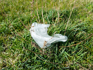 Obraz premium Coronavirus plastic waste polluting the environment, disposable foil gloves pollute the environment and pose a health hazard