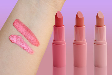 three tubes of lipstick and two abstract strokes on the female hand of pink, natural color, sample...