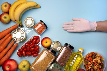 A gloved hand points to a grocery anti-crisis set of products for delivery from an online store....