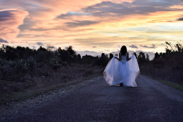Beautiful girl with charming look with a white wedding dress in the forest