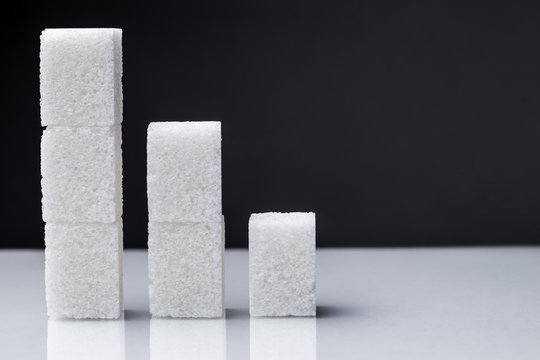 The Downward Chart Is Made Up Of Sugar Cubes. Sugar Reduction In Consumption сoncept.