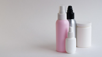 Bottles with tablets in white, pink, gray on a gray background. Copy space