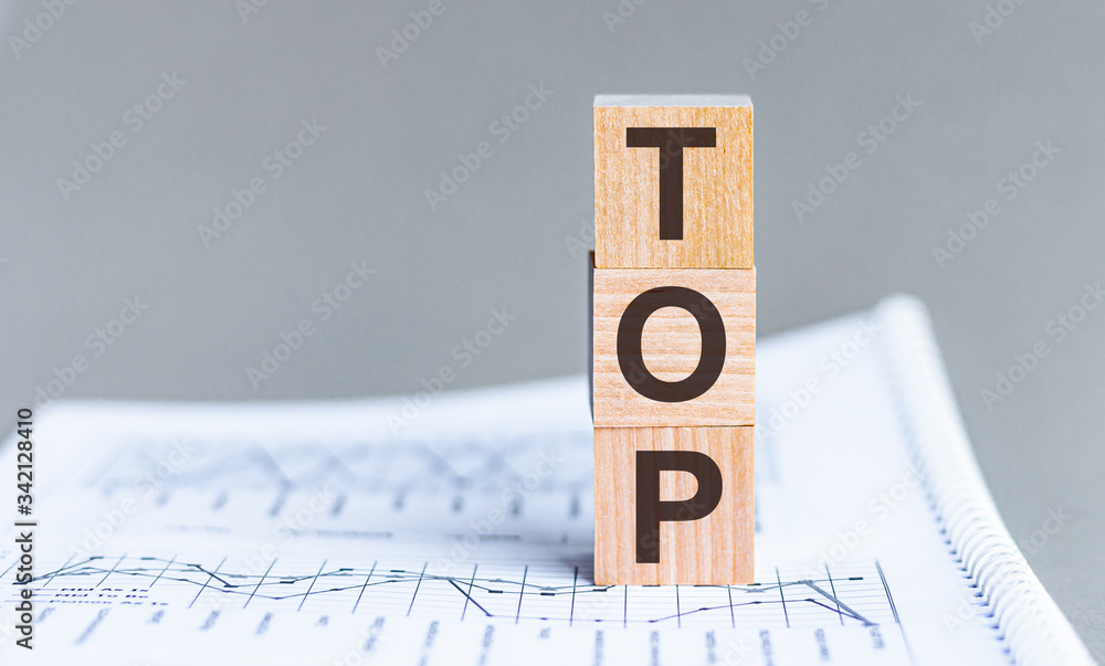 Fototapete top word written on wood block. top text on table for your desing, top view concept