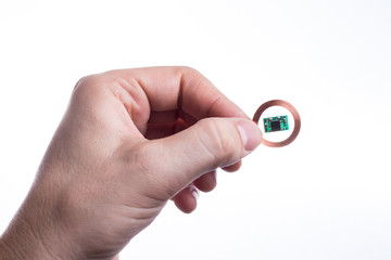 A person holds a radio frequency identification chip in his hand.