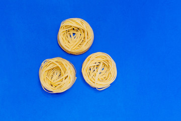 Three pasta raw yellow nests isolated