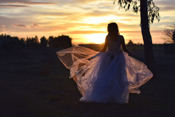 Fototapeta na wymiar Beautiful girl with charming look with a white wedding dress in the forest