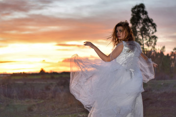 Fototapeta na wymiar Beautiful girl with charming look with a white wedding dress in the forest