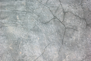 Old gray cement wall surface with cracks.