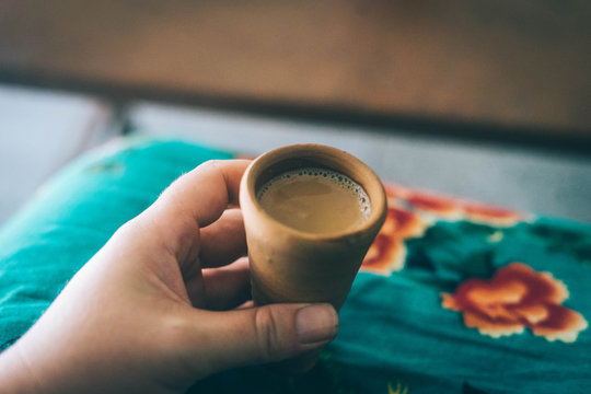 Close-up Of Cropped Hand Holding Coffee In Clay Cup