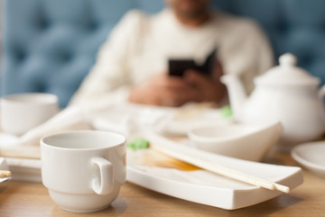 man with a phone in his hands is drinking tea