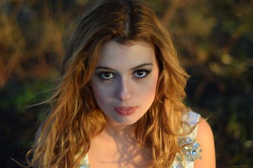 Naklejka premium Beautiful girl with charming look with a white wedding dress in the forest