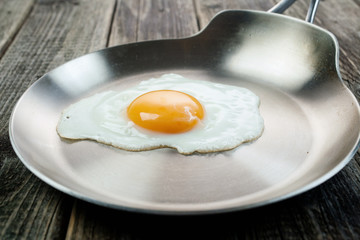 Eggs from one egg on a steel pan on a wooden background