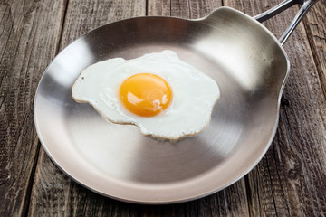 Eggs from one egg on a steel pan on a wooden background