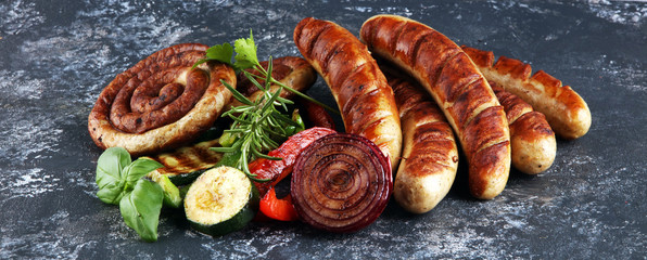 Assorted delicious grilled meat with vegetable on a barbecue with grilled sausages and vegetables on table