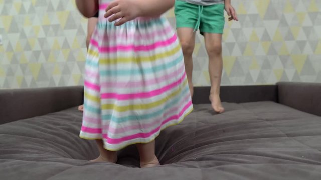 children jump on the bed, close-up shooting of jumping feet