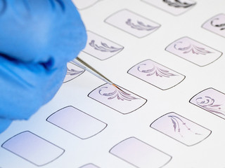 Training in painting monograms for manicure. Training cards for manicure, close up. 