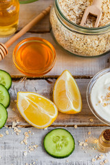 Concept of natural organic ingredients in cosmetology, home treatment in quarantine. Do it yourselft. Handmade mask with honey, egg, oat, lemon, cucumber, essential oils. Wooden background top view 