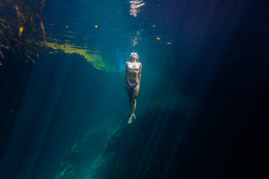 A woman snorkels in crystal blue water