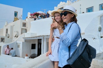 Happy mother and child daughter enjoying scenic views of Santorini