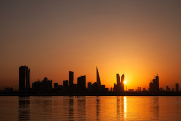 Fototapeta na wymiar Bahrain skyline and fishing boat at sunset
