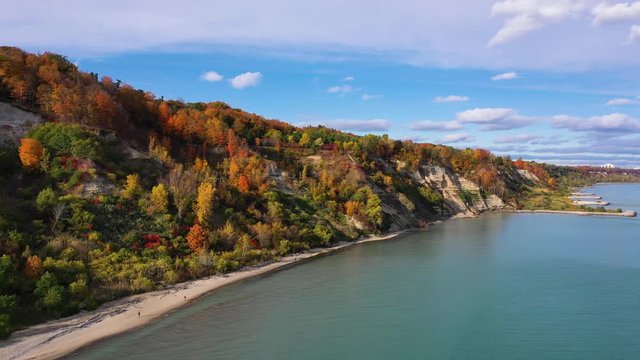 Drone footage of shore cliffs with colorful autumn trees
