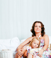 Portrait of smiling young mother and daughter at home, happy family together having fun, lifestyle...