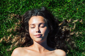 young cute summer girl on green grass outside relaxing smiling close up sunny vacation, lifestyle real people concept