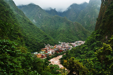 The Urubamba River flowing through the town of Aguas Calientes and the green Andes mountains, Cusco, Peru, South America