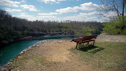 A metal bench sitting at the edge of an old limestone quarry at France Park in Cass county near Logansport Indiana 