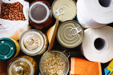 Close up of non-perishable food, canned goods and toilet paper. Overhead view. - obrazy, fototapety, plakaty