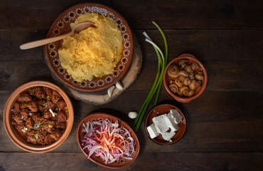 Traditional Eastern European corn mush (mamaliga, polenta, banosh, balmes) served with side dishes and vegan seitan