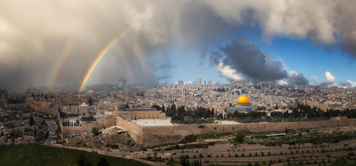 Naklejka premium Beautiful panoramic aerial view of the Old City, Tomb of the Prophets and Dome of the Rock. Dramatic Rain and Rainbow Sky Composite. Jerusalem, Capital of Israel.