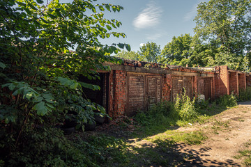 Old, damaged red brick garages