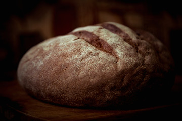 round bread, lying on a brown, wooden Board
