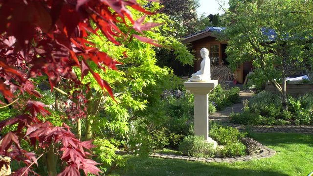Gartenlandschaft mit Gartenhaus und Buddha Figur