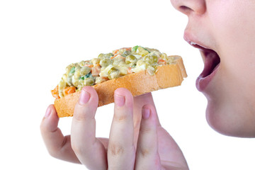 Girl eats vinaigrette of various boiled vegetables with bread