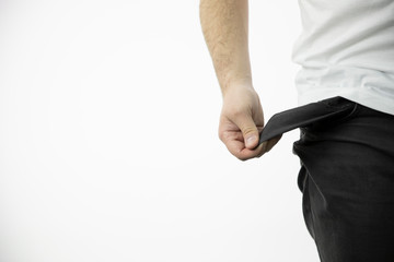 man's hand shows an empty inside-out black pants pocket isolated on white background copy space close up . concept of poverty, cash is out