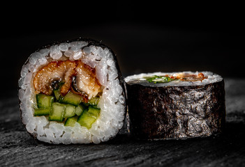 sushi roll with fish and rice on black wooden table background